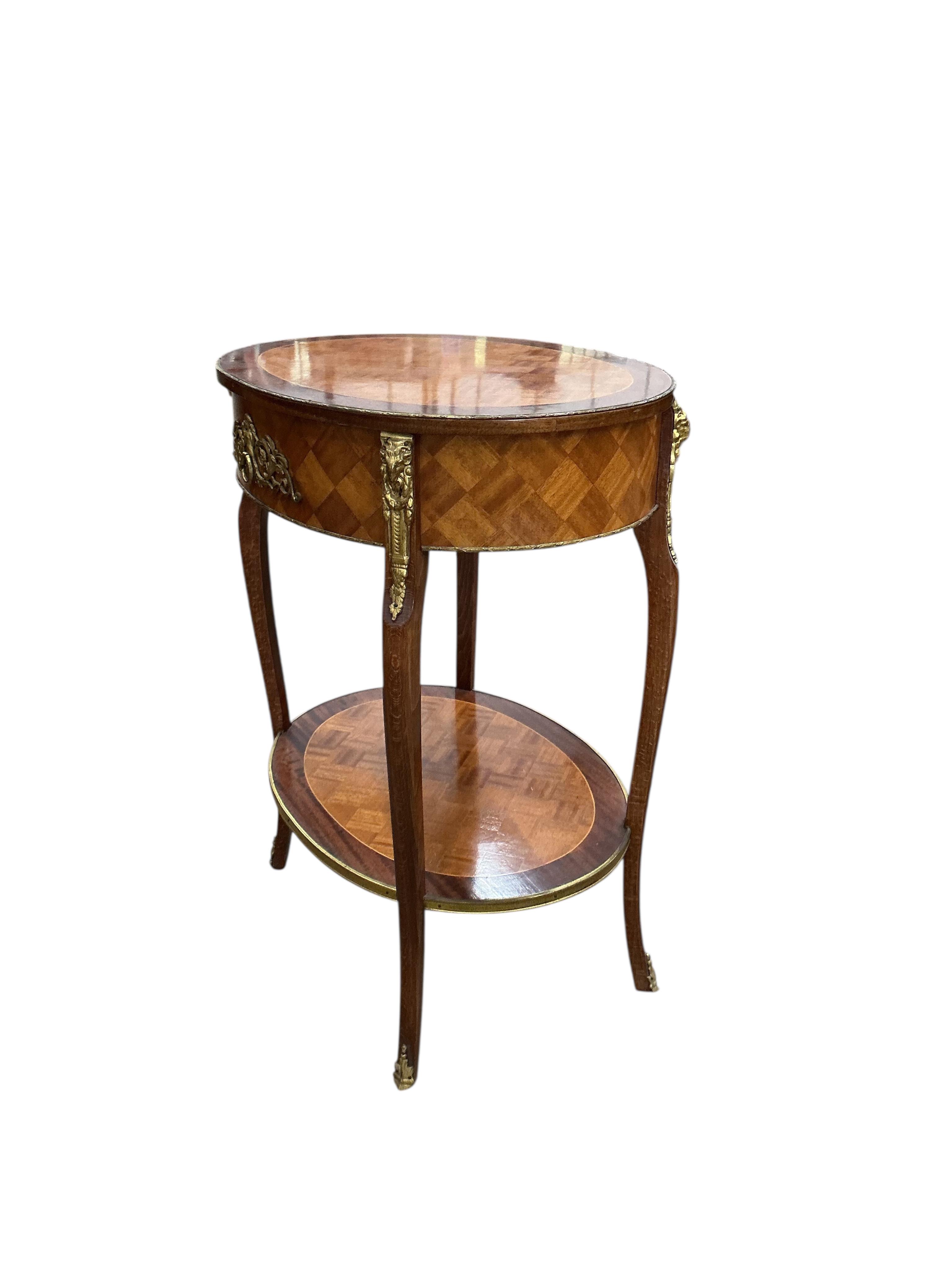 An early 20th century French transitional style gilt metal mounted satinwood parquetry and mahogany oval two tier table, width 53cm, depth 41cm, height 68cm